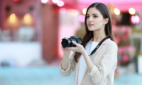 Canon EOS R100 mirrorless camera with lens attached