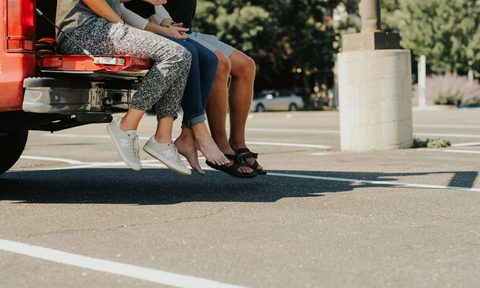 Group sitting on tailgate in parking lot