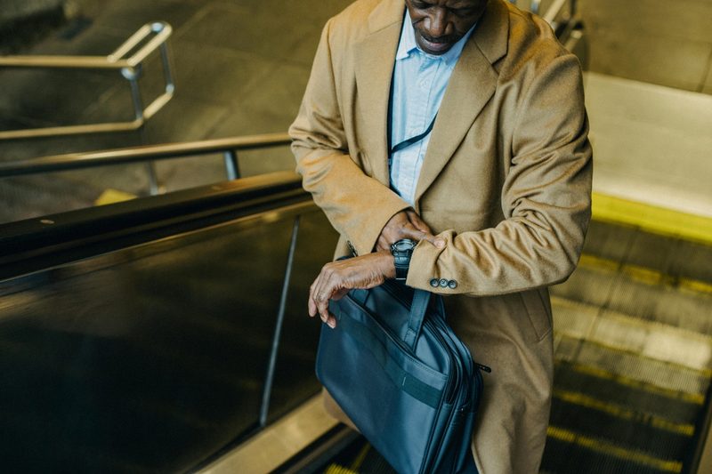 Man in trench coat checking his watch