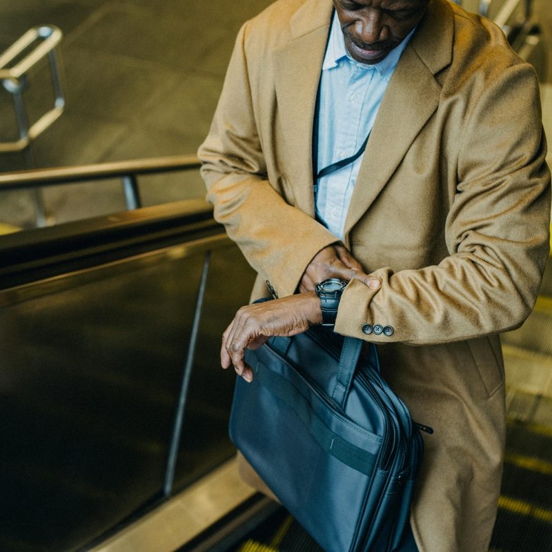 Man in trench coat checking his watch