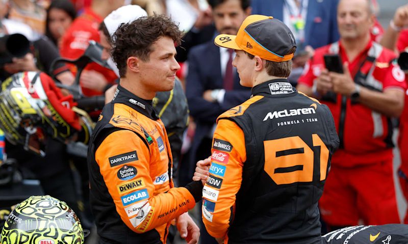 McLaren F1 drivers Lando Norris and Oscar Piastri clasping hands after Italian Grand Prix.