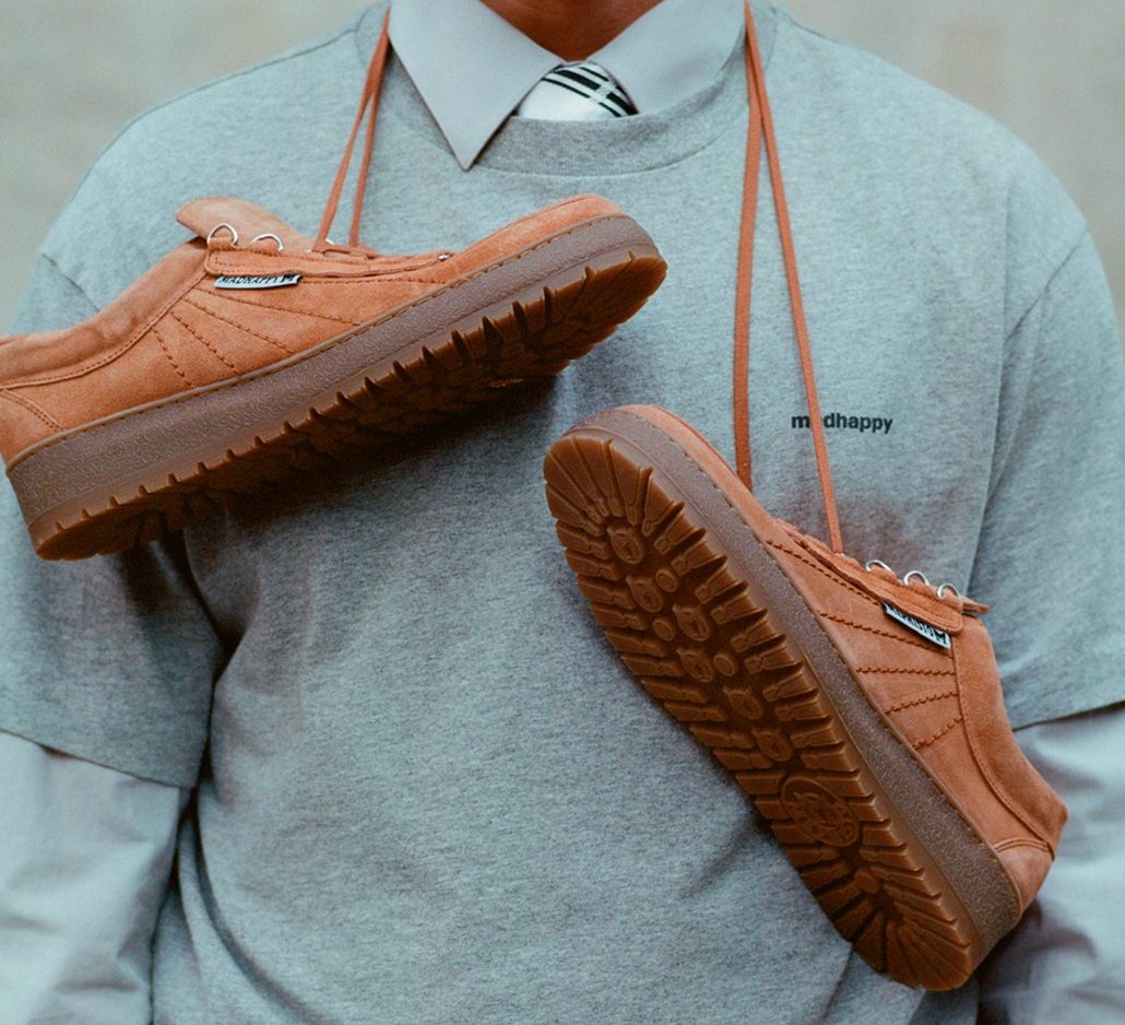 man with mephisto and madhappy sneakers hanging around chest