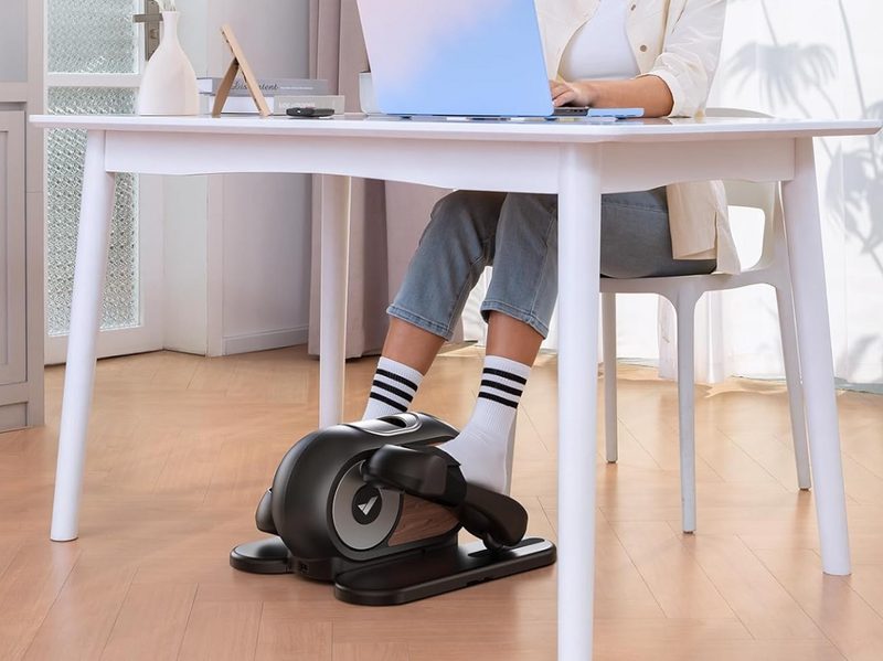 A woman using the Merach Under Desk Elliptical.