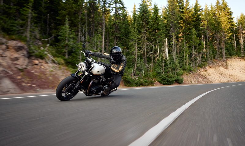 Next generation 2025 Triumph Speed Twin 1200 on highway with forested land the background.