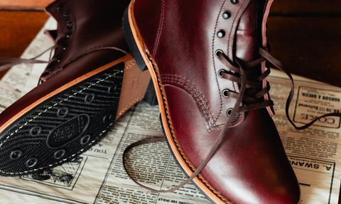 black cherry Red Wing Shoe Co boot sitting on top of newspaper
