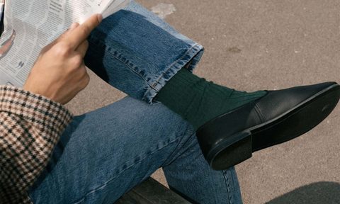 man sitting on bench wearing black slipper shoes