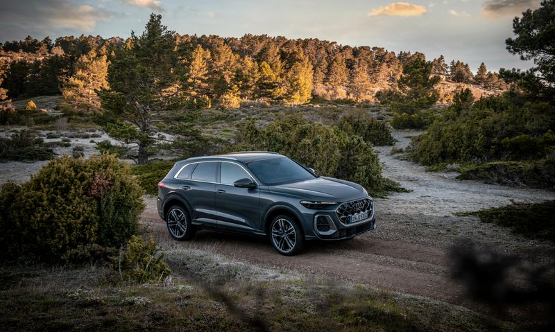 Third generation Audi Q5 driving on a dirt road with forest in the background.