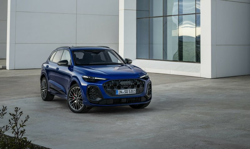 Third generation Audi SQ5 parked on a concrete surface in front a concrete and glass building.