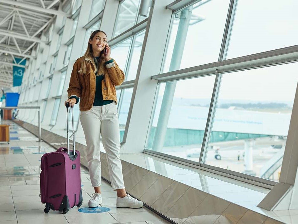 Woman in airport getting ready to book stay with Choice Hotels com