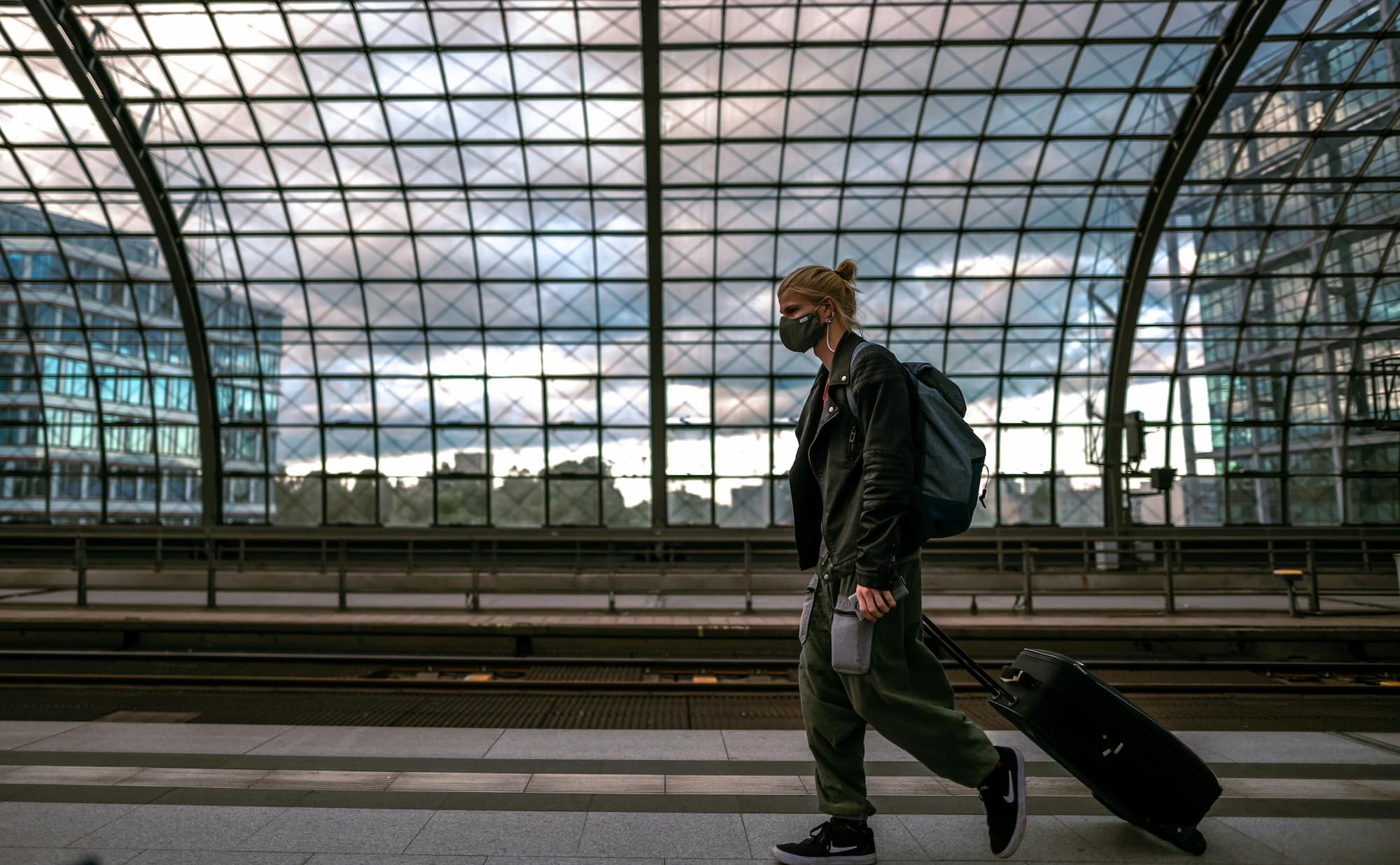 man walking with suitcase and backpack