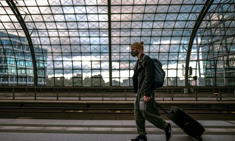 man walking with suitcase and backpack
