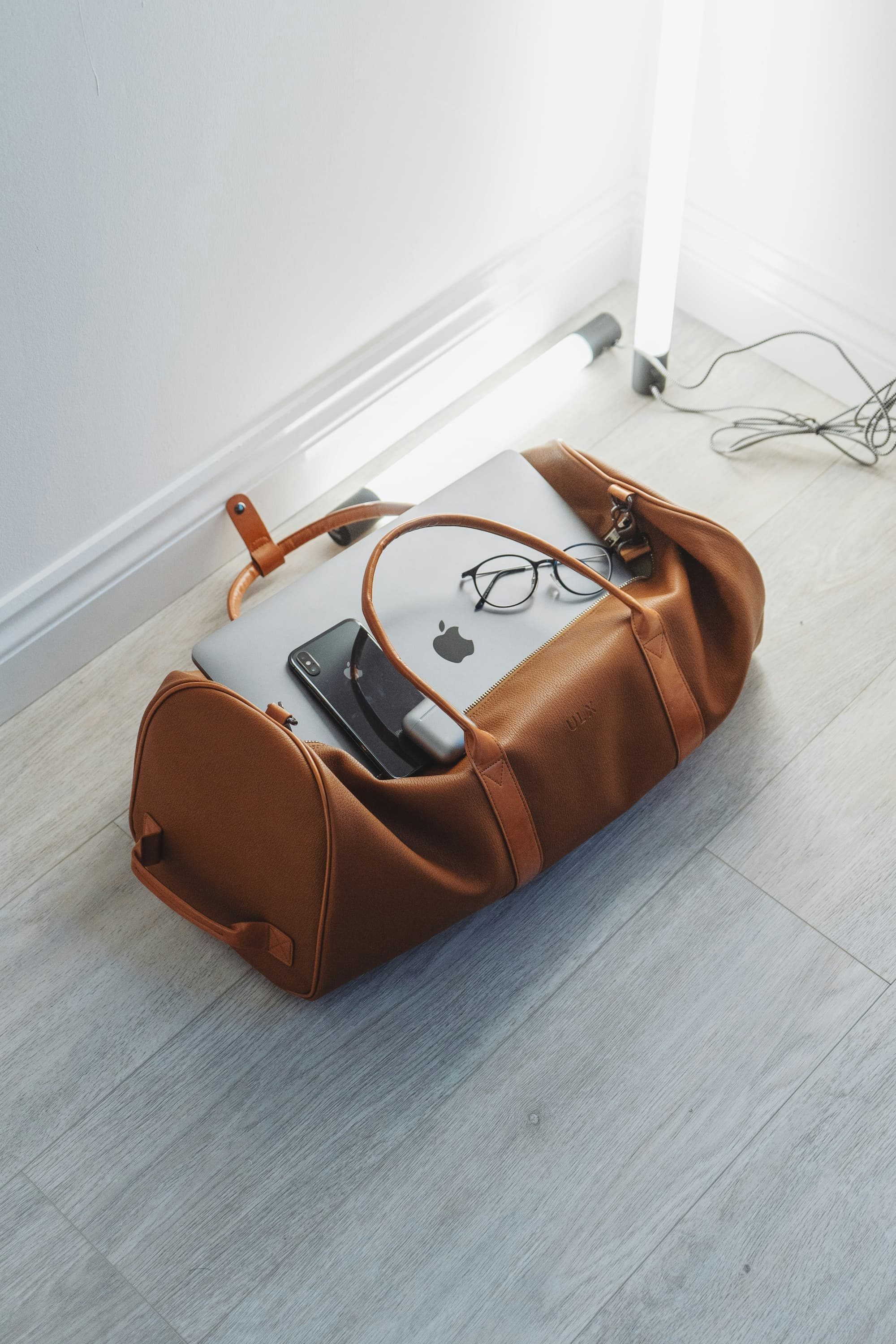 brown duffel bag on ground