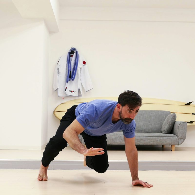 man doing bear crawl in room grey couch in background