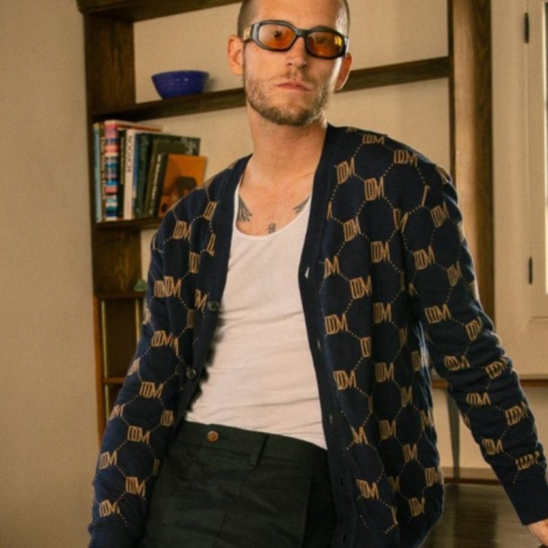 Man leaning on desk in a Dandy Del Mar cardigan