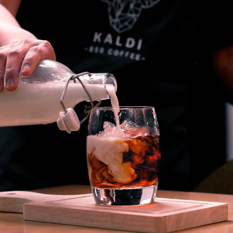 Pouring cream in cold brew coffee