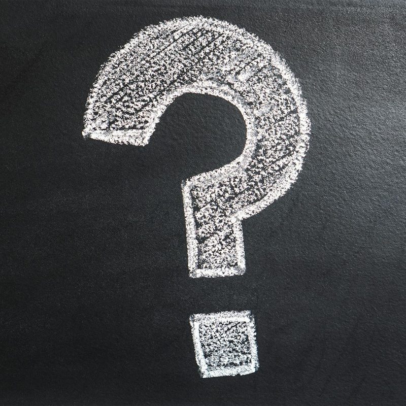 White chalk question mark on black chalkboard