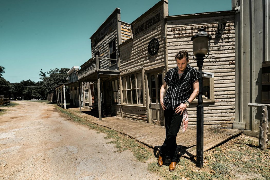 man wearing dark wash denim and cowboy boots