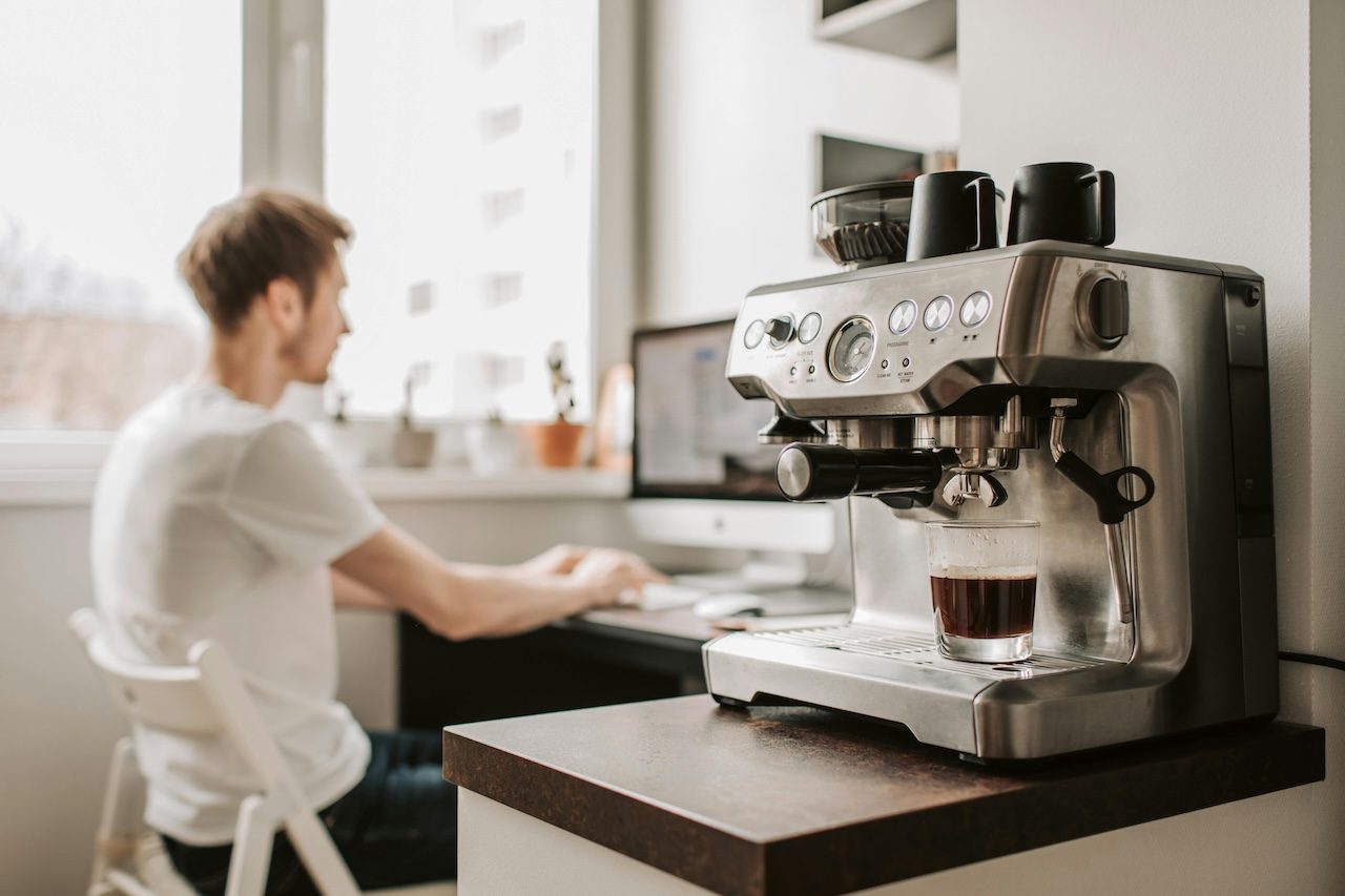 Espresso maker with a man in the background