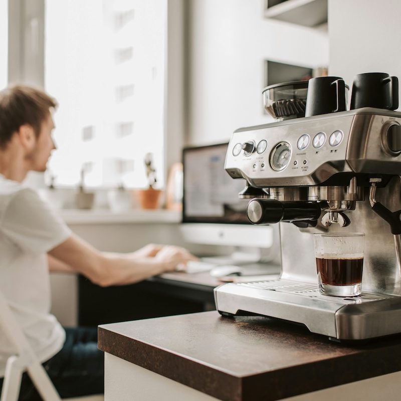 Espresso maker with a man in the background