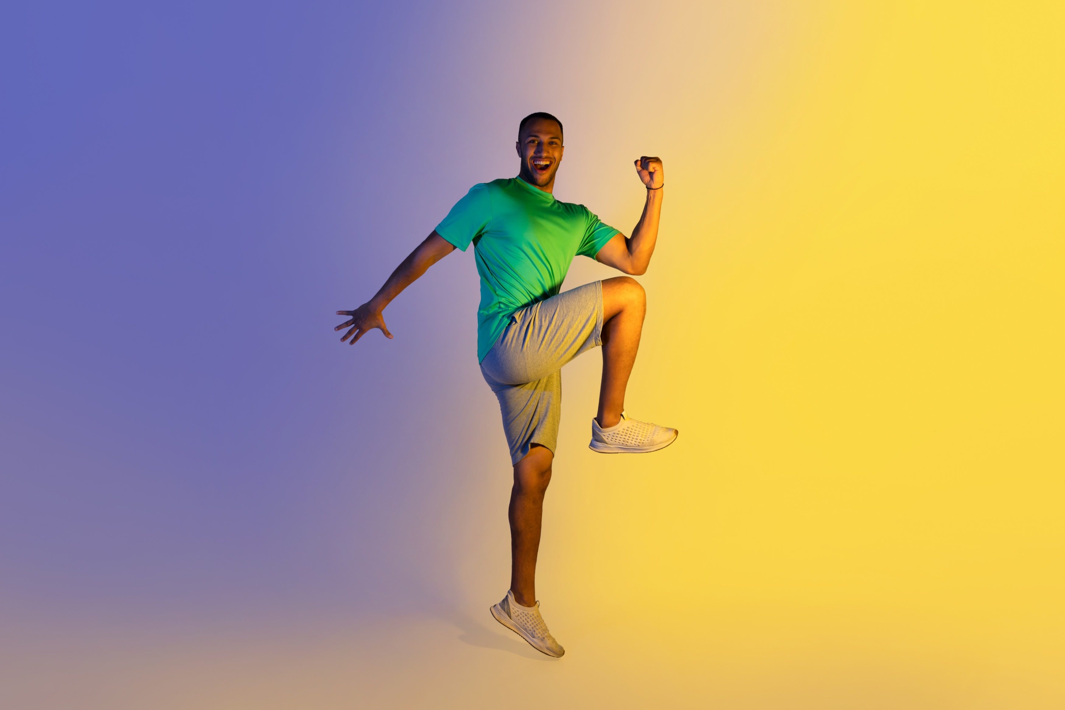 guy wearing green shirt jumping up doing oblique crunches exercise squat to oblique knee crunch workout