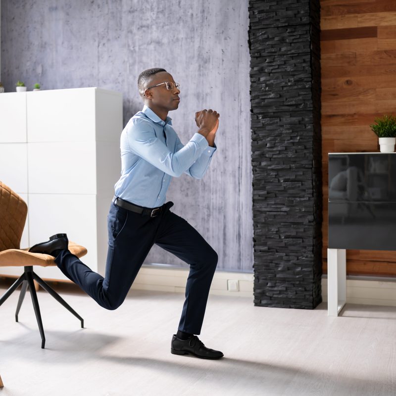 Man exercising in the office at work Bulgarian split squat