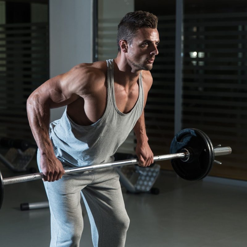 Man wearing gray vest doing bent-over barbell row