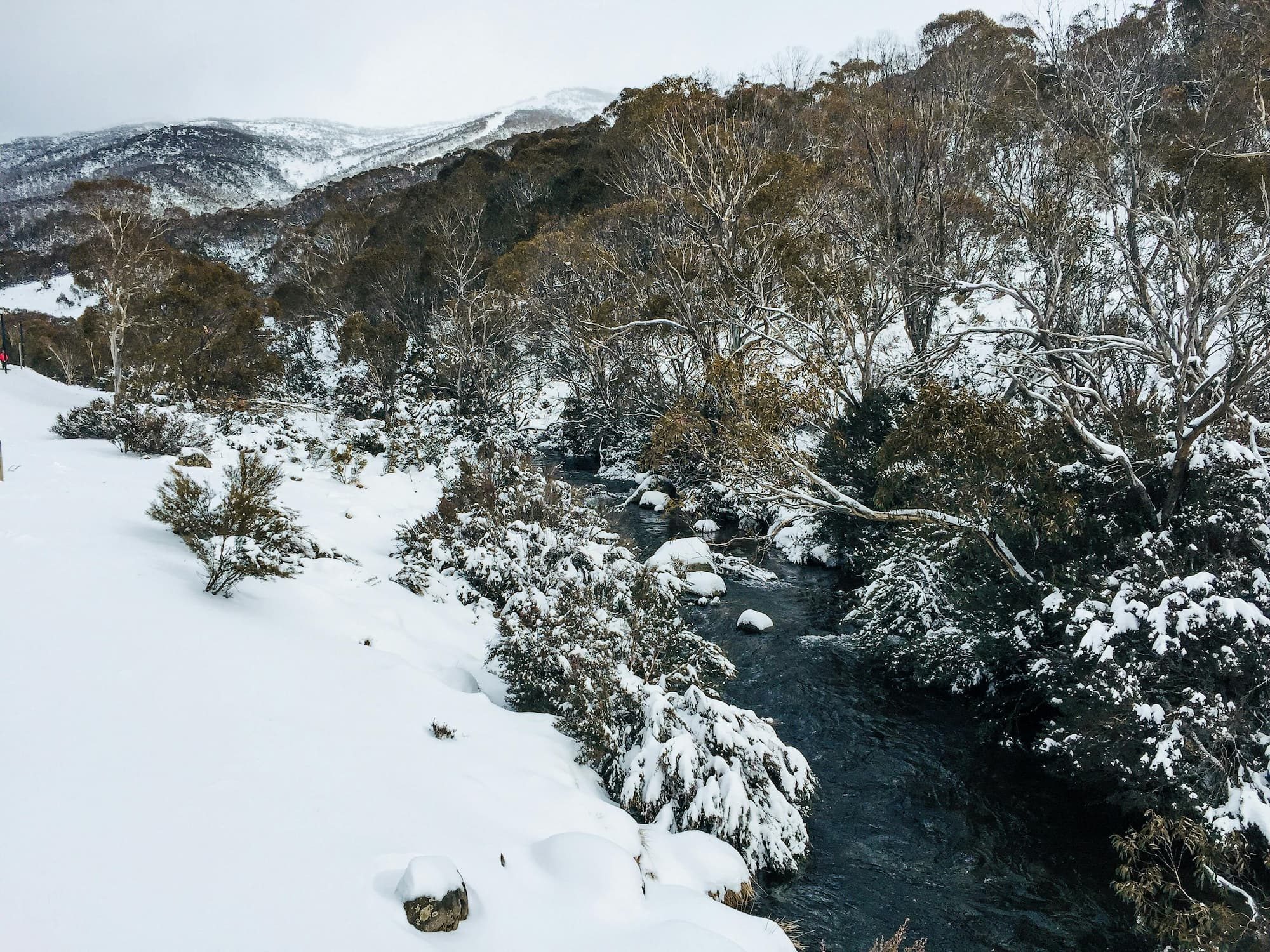 drone shot of a river in the snowy mountains