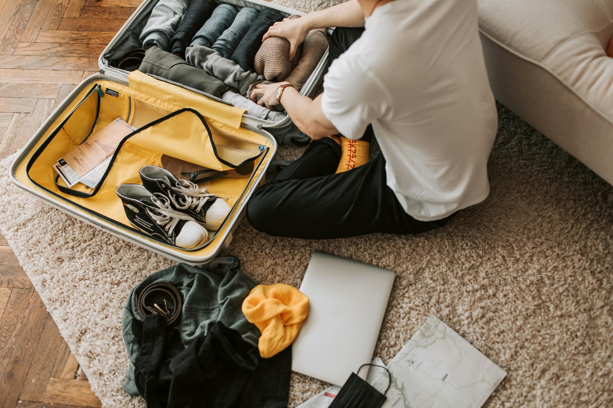 A man packing shoes in his suitcase