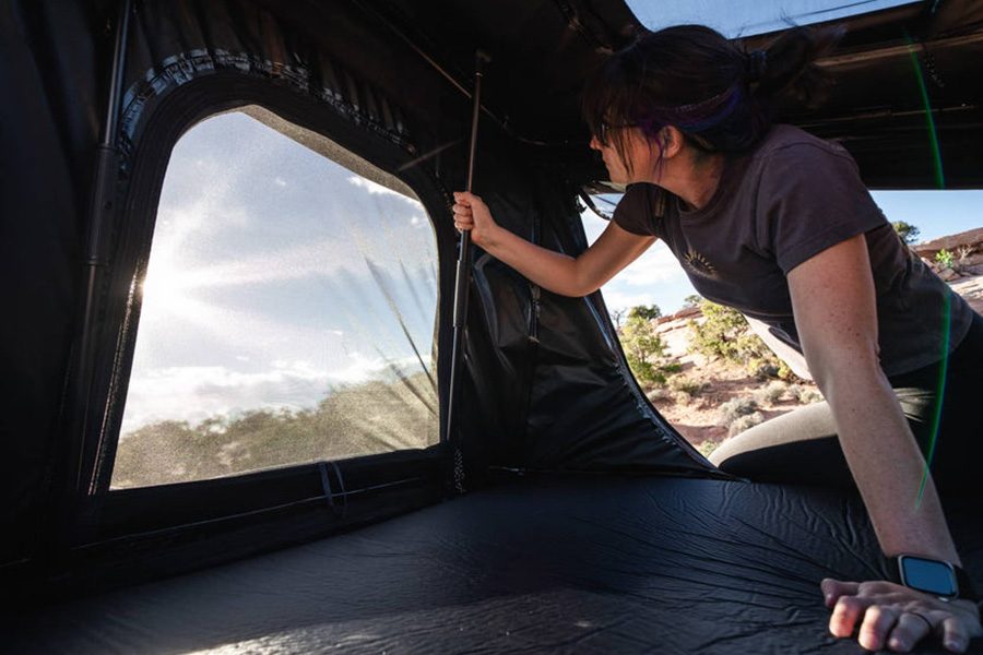 Person setting up the interior of the TentBox GO rooftop tent.