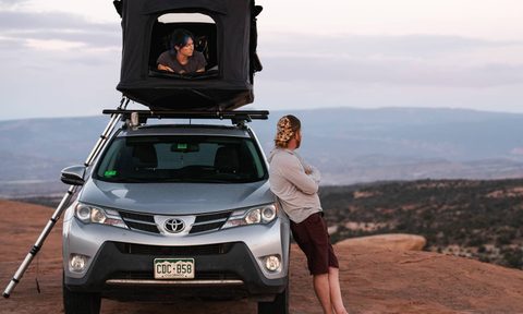 Couple using a TentBox GO rooftop tent in the desert.