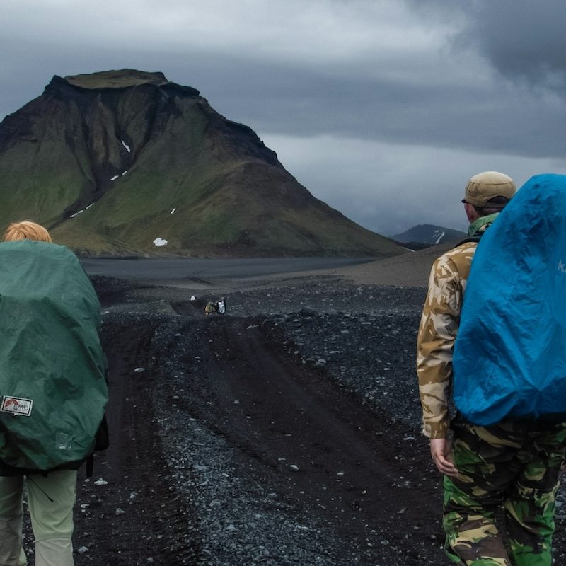 People with two large backpacks hiking