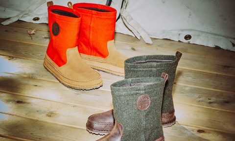 two boots sitting in tent on wood floor