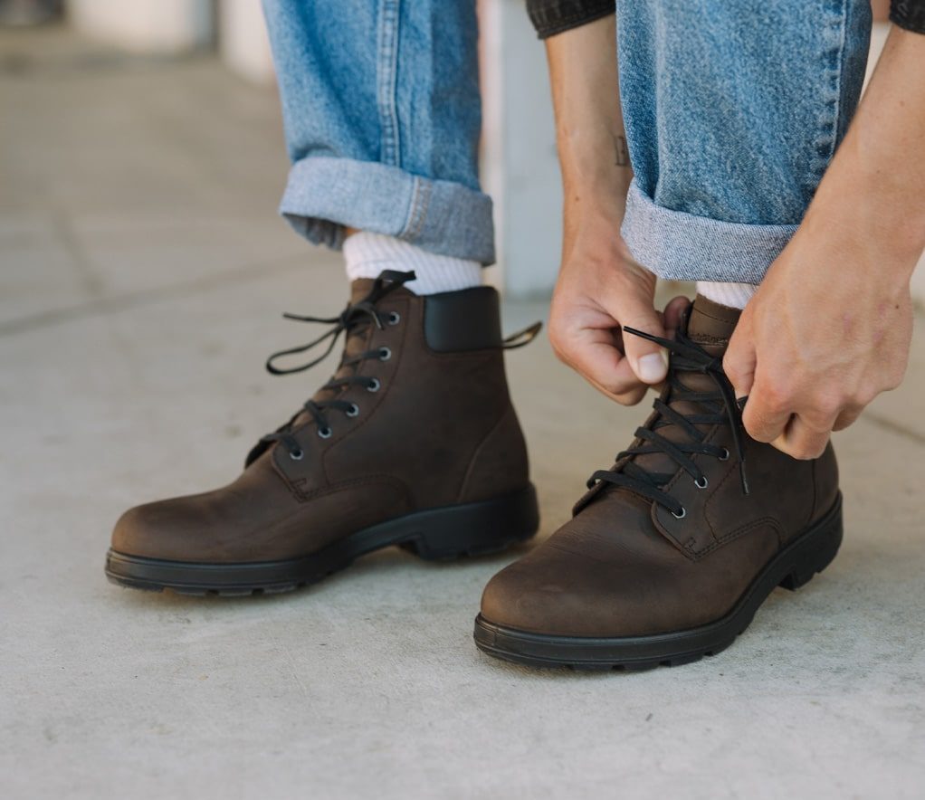 man lacing up blundstone lace up boots