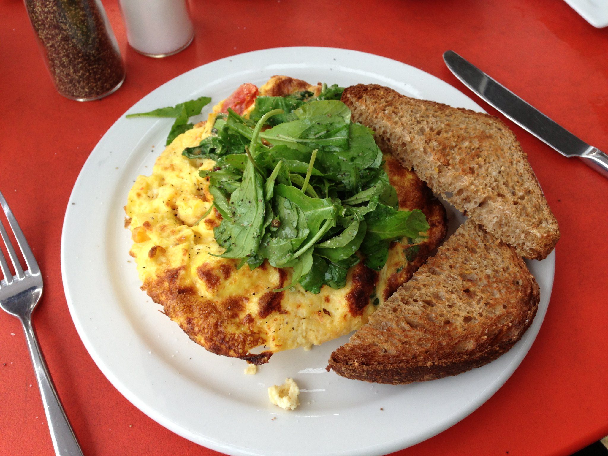 A plate of breakfast with greens ontop of it