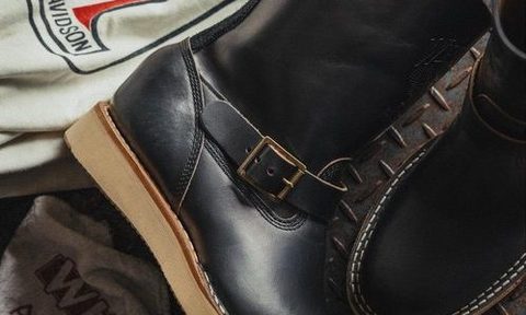 pair of black leather boots laying on table