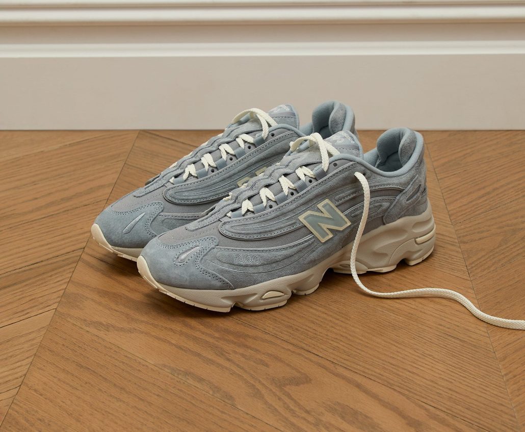 blue Kith and New Balance sneaker on wood floor