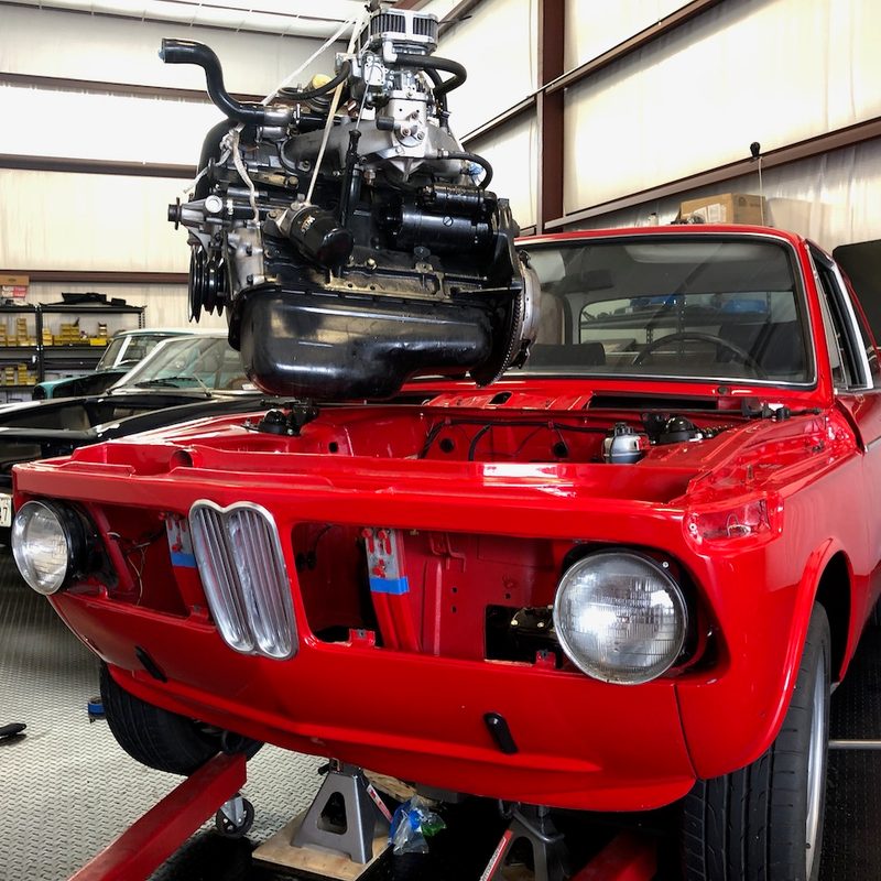 Moment Motor Company-engine being removed from red BMW for EV conversion