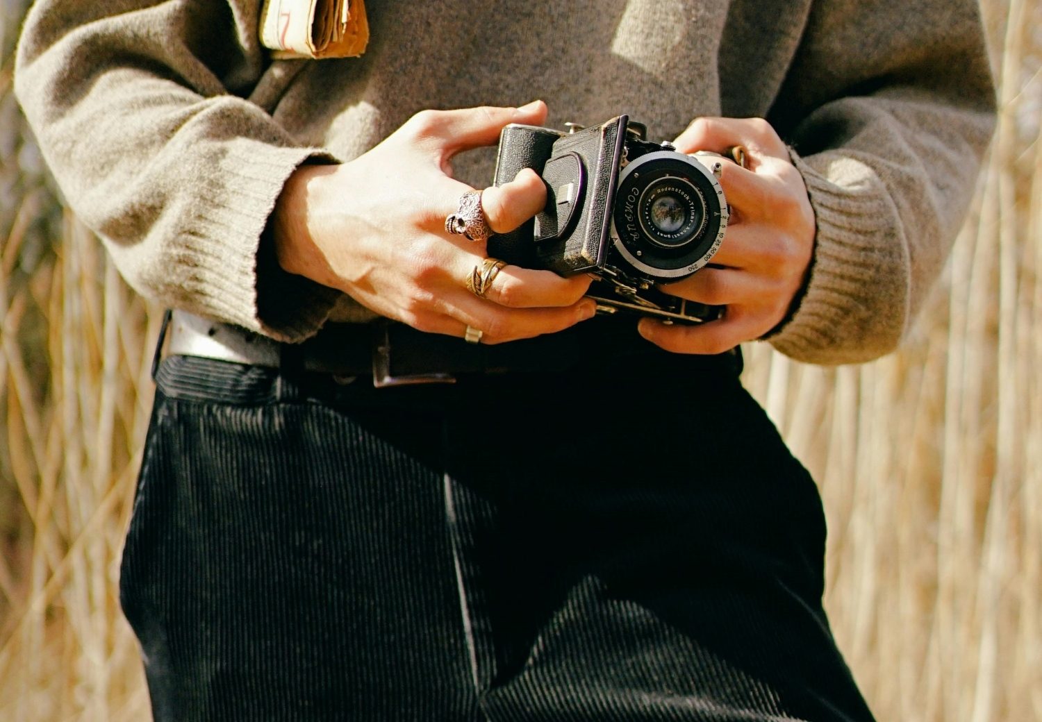 Man in cordurdoy pants holding camera