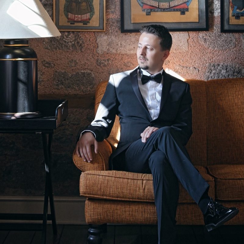 Man in a tux sitting on a couch