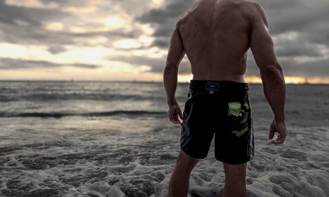 Man standing on the beach in boardshorts