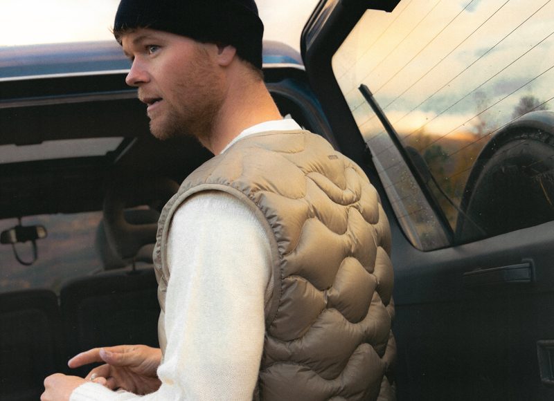 Man wearing Kestin vest by a car