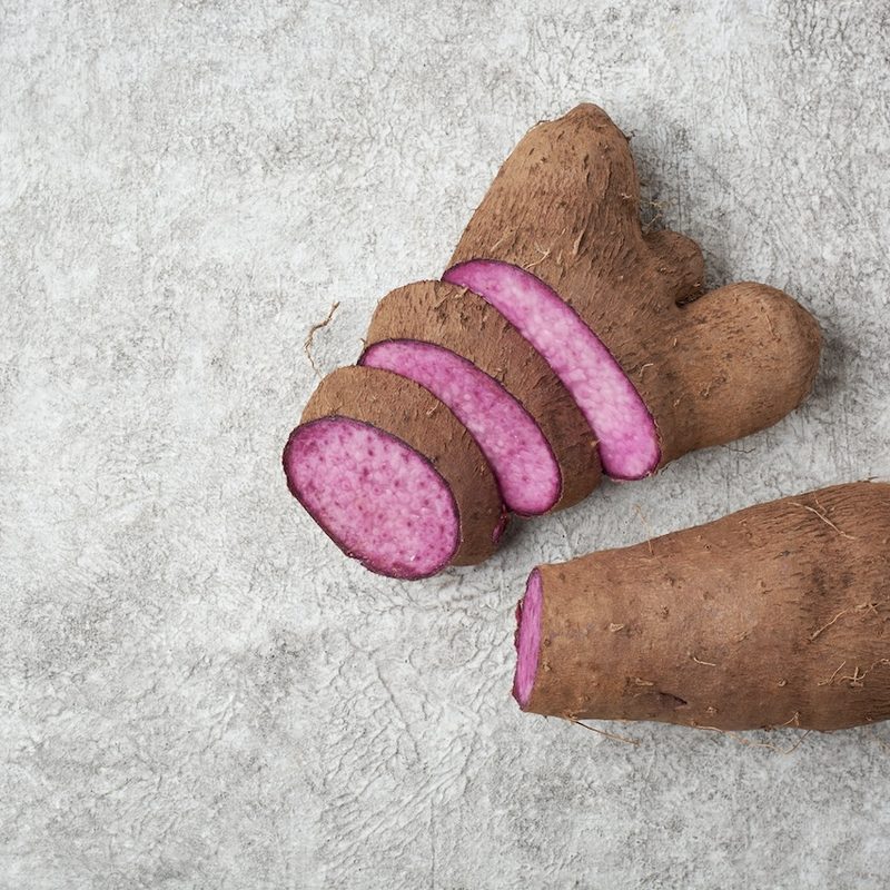 Ube, sliced purple yam on a white textured surface