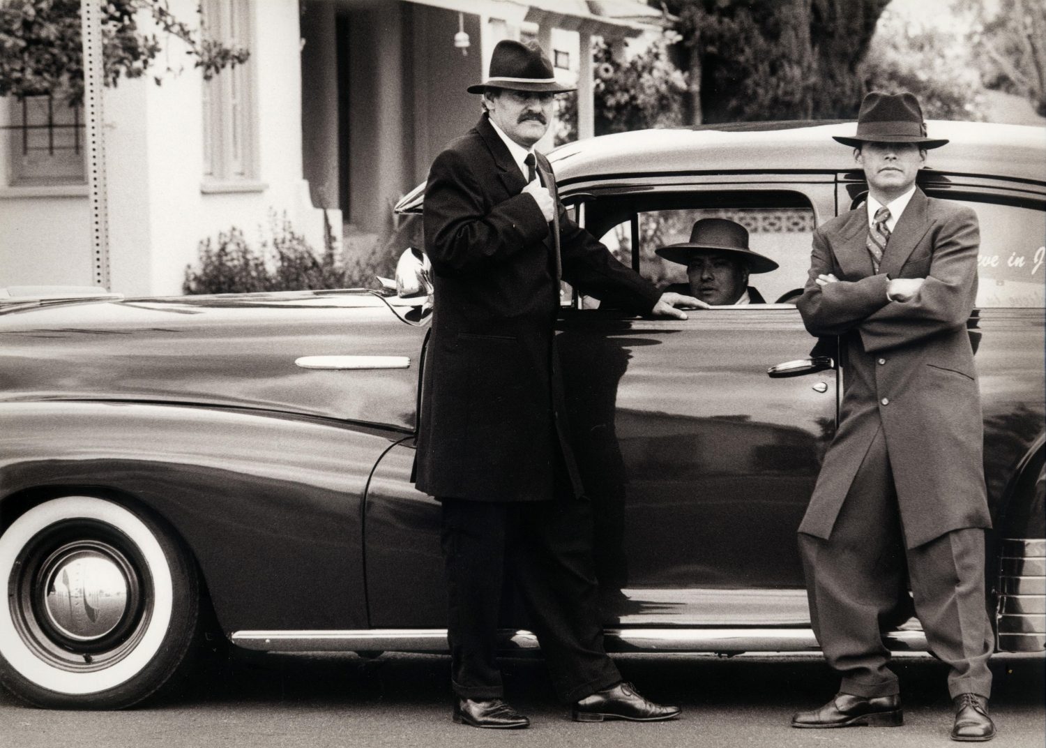 Vintage gangsters by a car