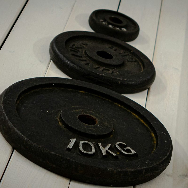 Weights on white wooden floor with barbell weight plates