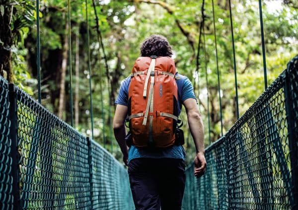 Man outside with orange backpack on