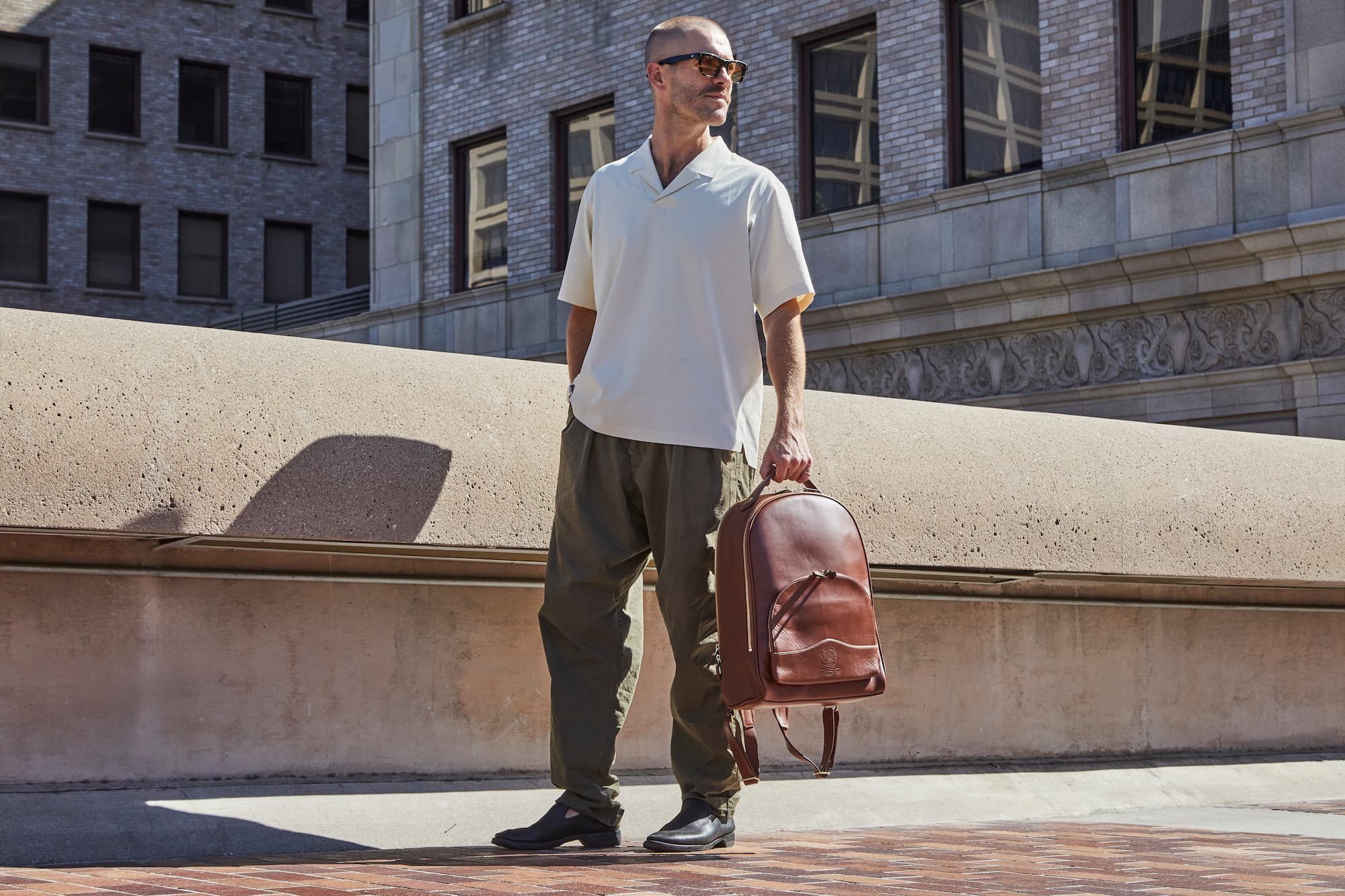 man standing outside with backpack in hand