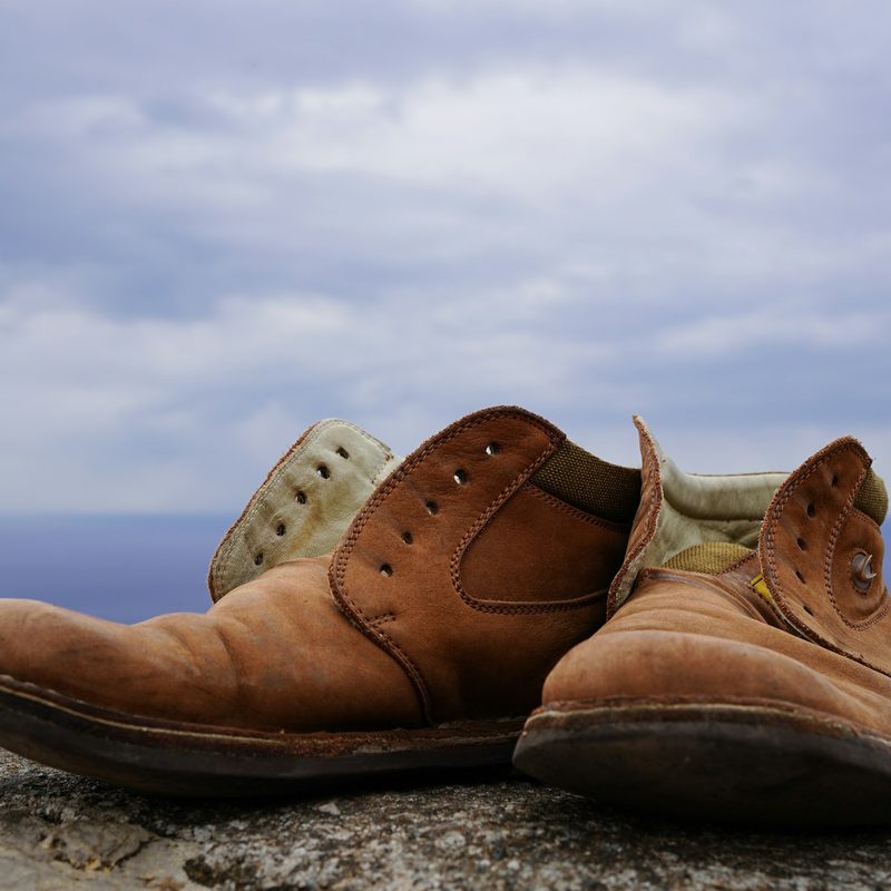 Unlaced suede boots sitting on rock