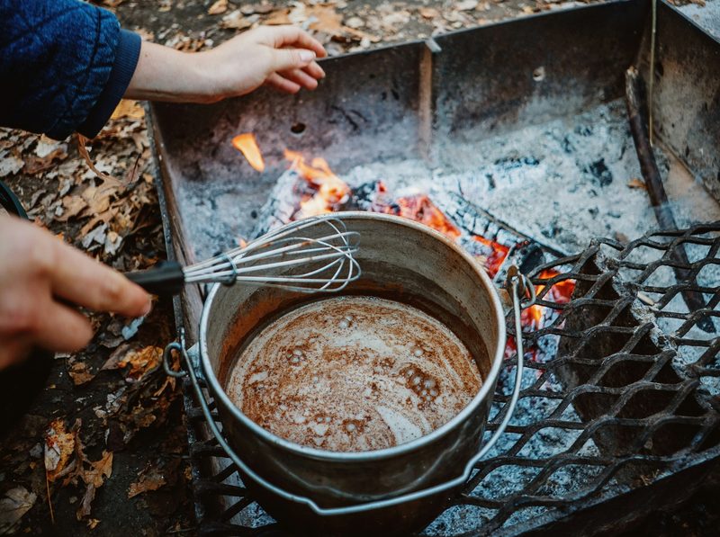 Hot chocolate cooking over a campfire