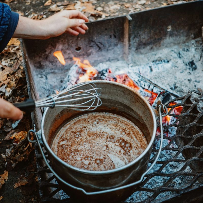 Hot chocolate cooking over a campfire