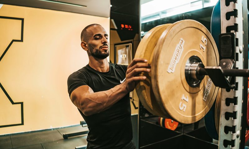 Man putting weight on a rack in the gym